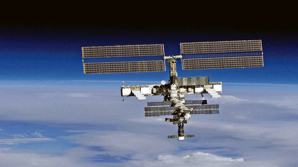 Die Internationale Raumstation ISS über der Erde. Auch sie ist der Kollisionsgefahr mit Weltraumschrott ausgesetzt.<br>