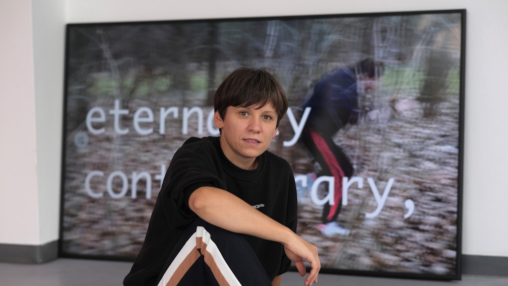 Marina Naprushkina against a backdrop of her video work Future for everyone (2020), part of her new exhibition <em>Keine Zeit für Kunst</em>