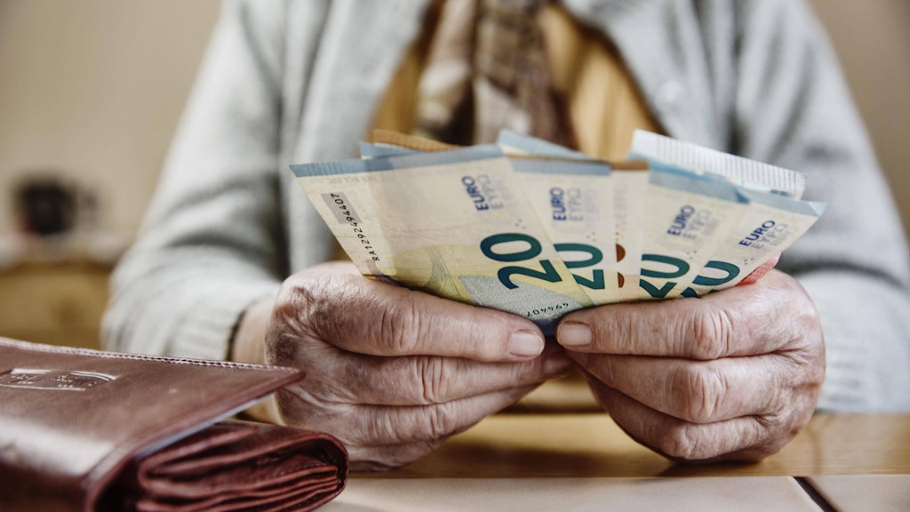 Eine Seniorin zählt ihr Geld.