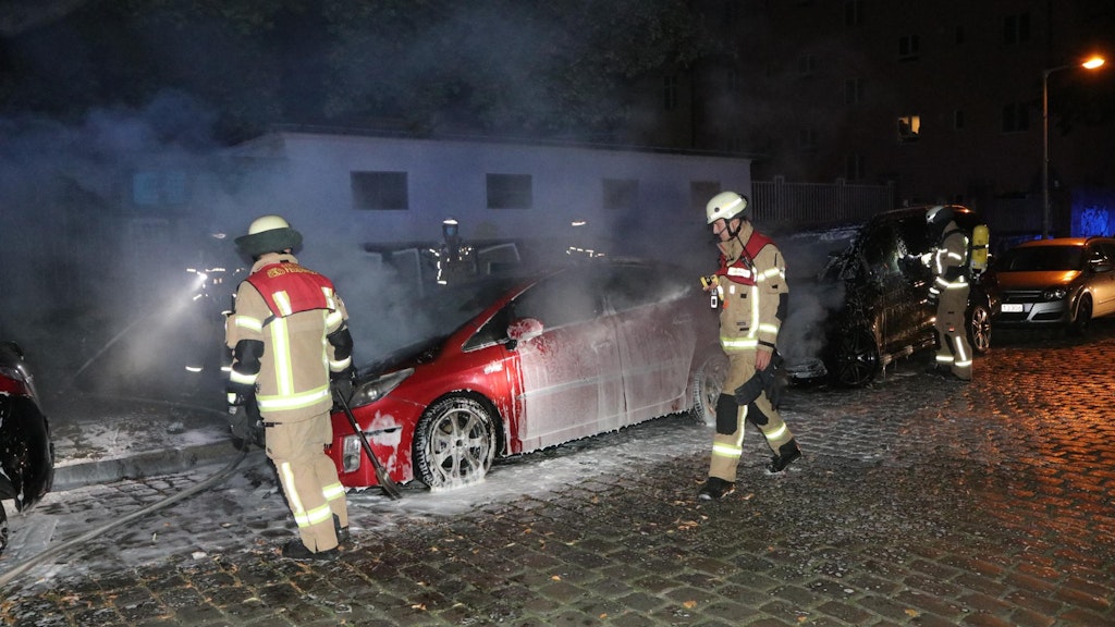 Feuerwehrleute löschen einen der Autobrände in der Schandauer Straße.
