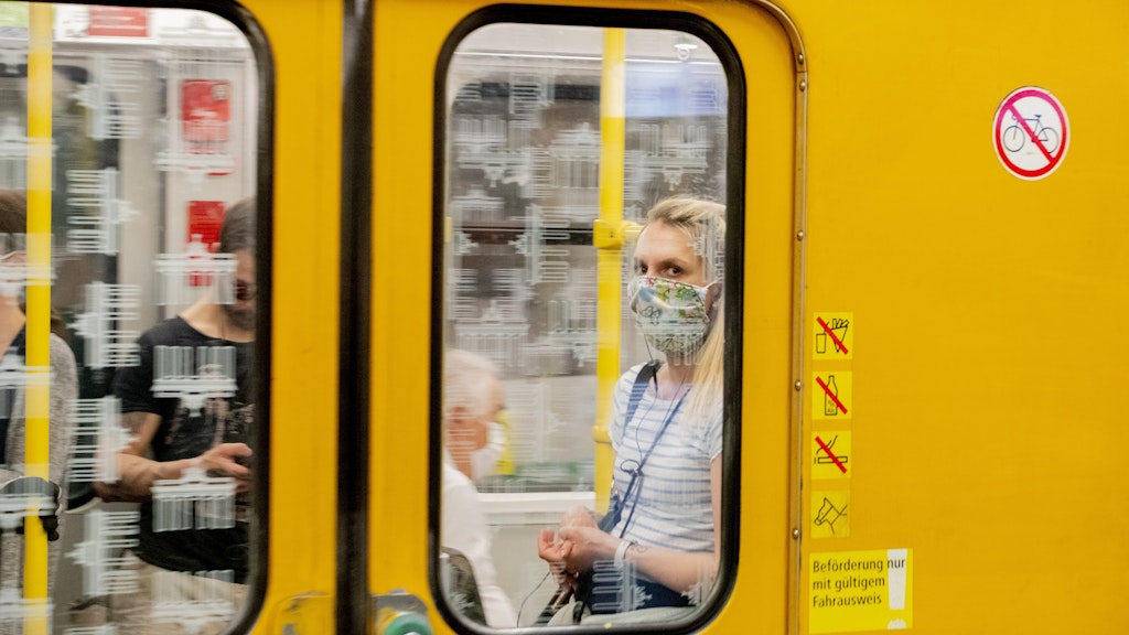 Eine Frau mit Mundschutz ist in einer Berliner U-Bahn zu sehen.
