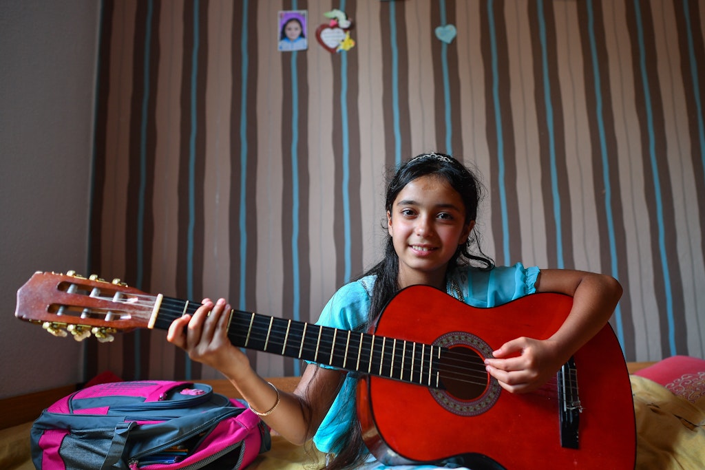 Die 14-jährige Nour spielt in ihrem Zimmer auf einer Gitarre.