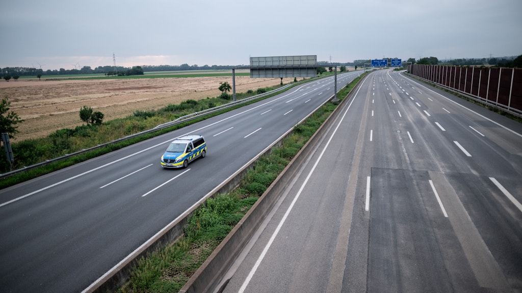 Ein Wagen der Polizei fährt über die gesperrte Autobahn A1 nahe Blessem in Erftstadt.