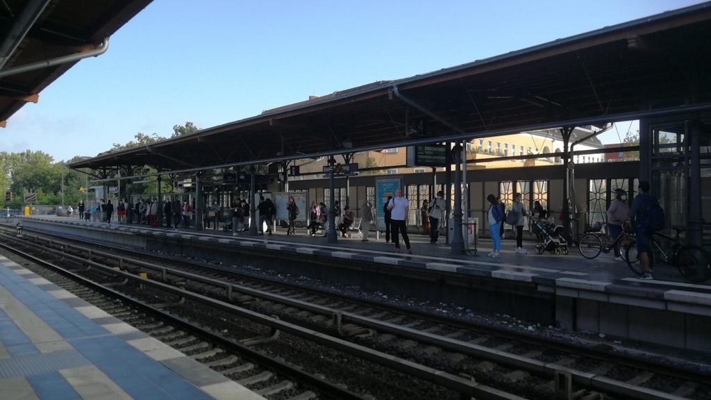 Am Umsteigebahnhof Baumschulenweg warten Fahrgäste auf eine S-Bahn.