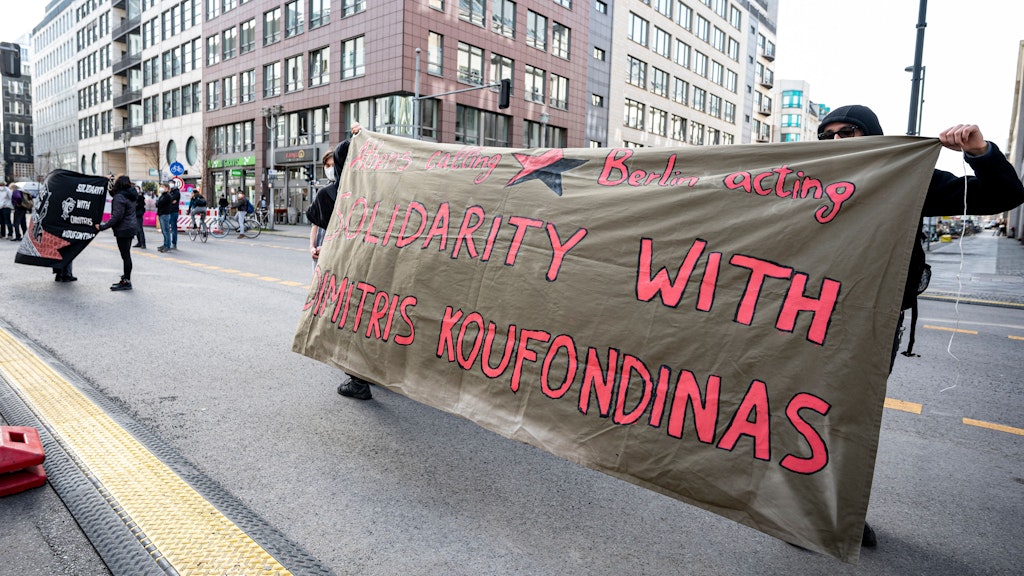 Demonstranten stehen mit einem Banner mit der Aufschrift „Solidarity with Dimitris Koufondinas“ vor dem besetzten griechischen Konsulat.