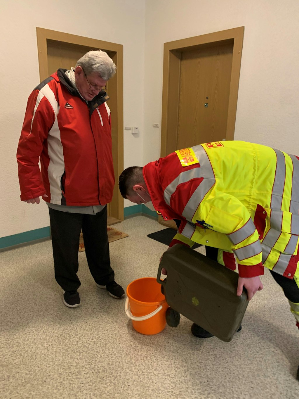 Dieter Bartling (68), Bewohner der Falkenberger Chaussee 42, bekommt Wasser von den Einsatzkräften des ASB.