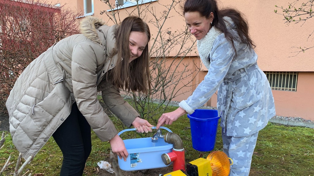 Mutter Nicole Völker (32, rechts im Bild) mit Tochter Samantha (12) an der Notzapfsäule in der Rüdickenstraße. 