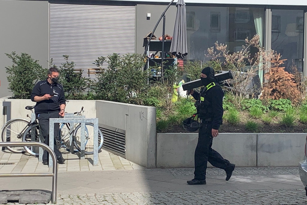 Ein Polizist spaziert nach dem Zugriff mit einer Ramme über den Gehweg an der Stallschreiberstraße. 