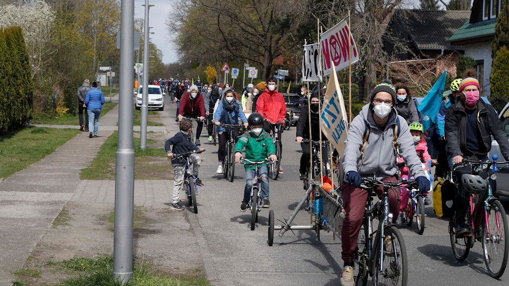 Eltern und Kinder fahren zusammen durch ein Wohngebiet im Osten Berlins. 