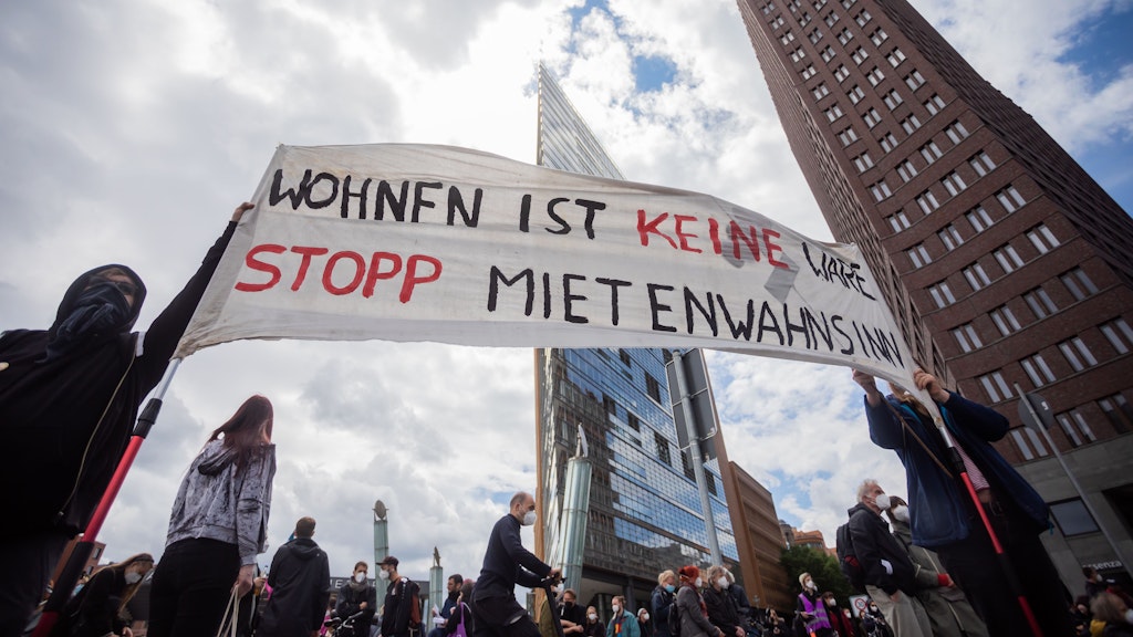 Potsdamer Platz: Teilnehmer der Mietendemo halten ein Banner mit der Aufschrift „Wohnen ist keine Ware, stopp Mietenwahnsinn“.