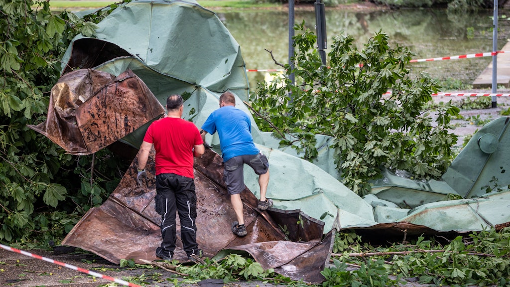 Baden-Württemberg: Männer arbeiten mit einem Winkelschleifer an einem Dachteil des Opernhauses in Stuttgart, das nach einem starken Unwetter vom Gebäude gefegt worden war.