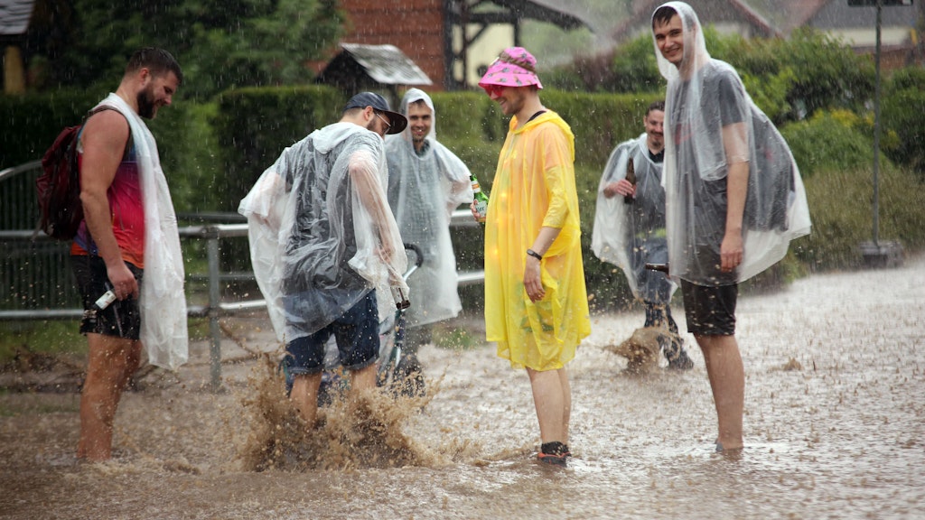 In Wernigerode in Sachsen-Anhalt machen junge Männer trotz starken Regengüsse einen Spaziergang. 