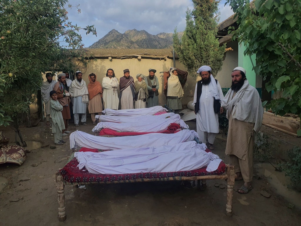 Men stand around the remains of victims who lost their lives in the earthquake in the village of Gayan in Afghanistan's Paktika province.  