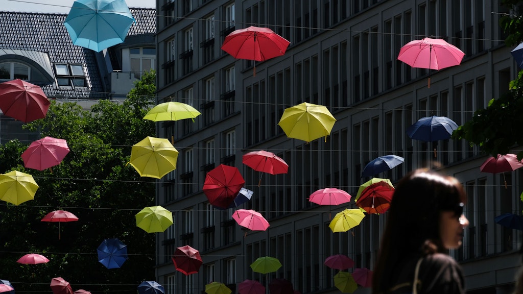 Regenschirme, die am Walter-Benjamin-Platz hängen, werden am Freitag kaum benötigt. Im Freien bleibt es trocken.