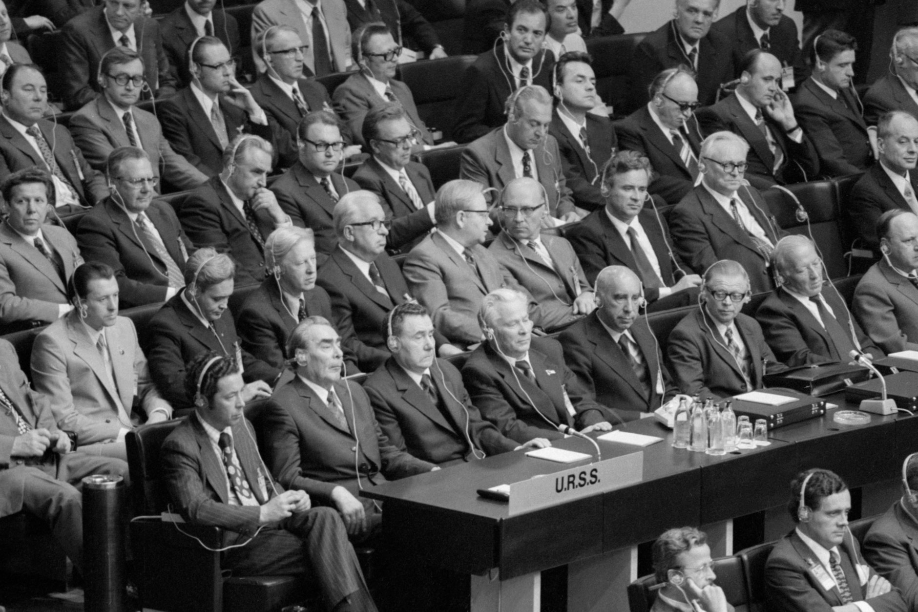 O intérprete Viktor Sukhodrev, o secretário-geral do Comitê Central do Partido Comunista da União Soviética Leonid Brezhnev, o ministro das Relações Exteriores da URSS Andrei Gromyko e o secretário do Comitê Central do PCUS Konstantin Chernenko (da esquerda para a direita, na frente) participam da sessão de encerramento da Conferência sobre Segurança e Cooperação na Europa no Palácio da Finlândia.