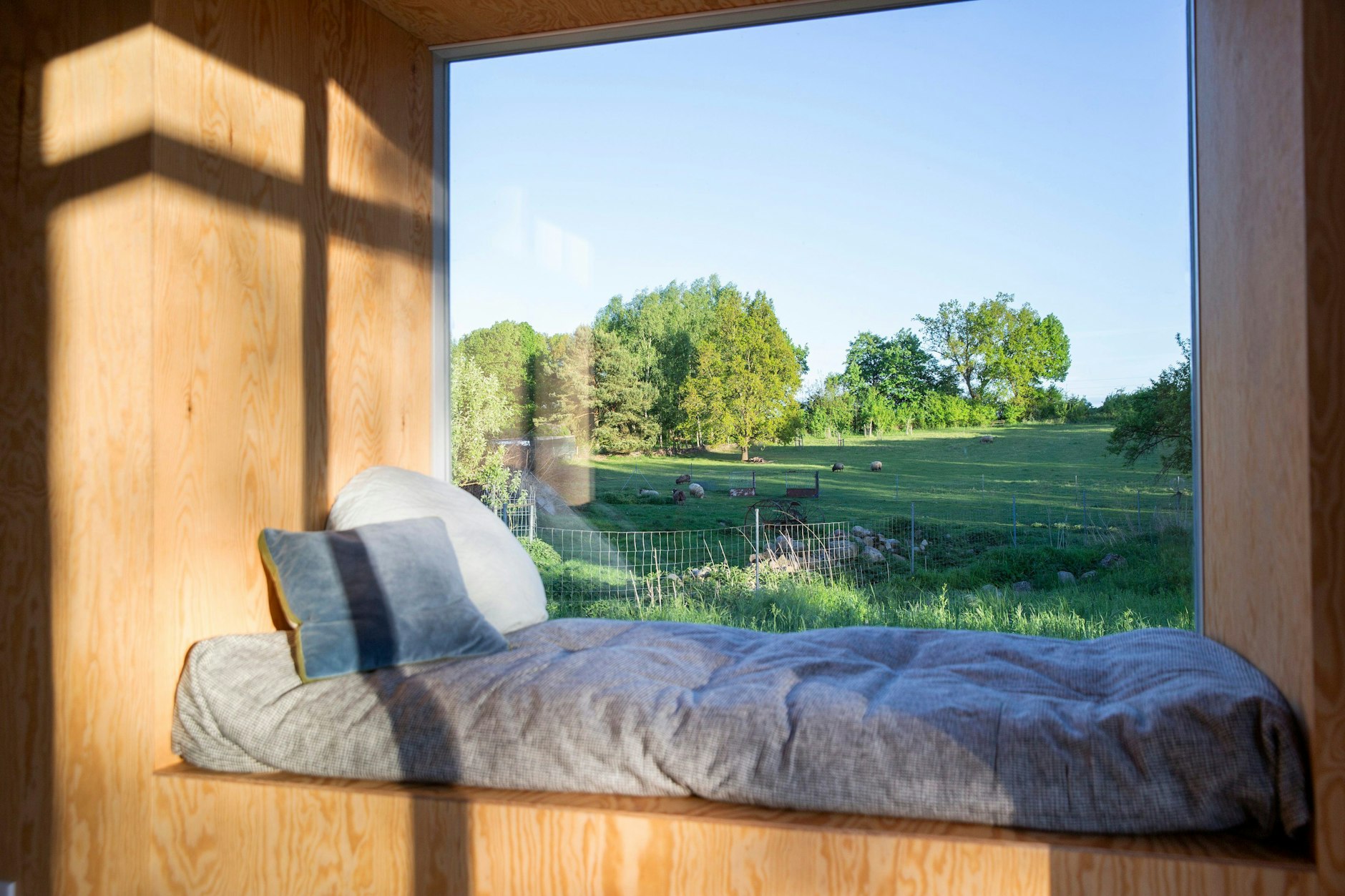 Panoramic windows with benches are designed in a style reminiscent of an iconic architectural project in California.