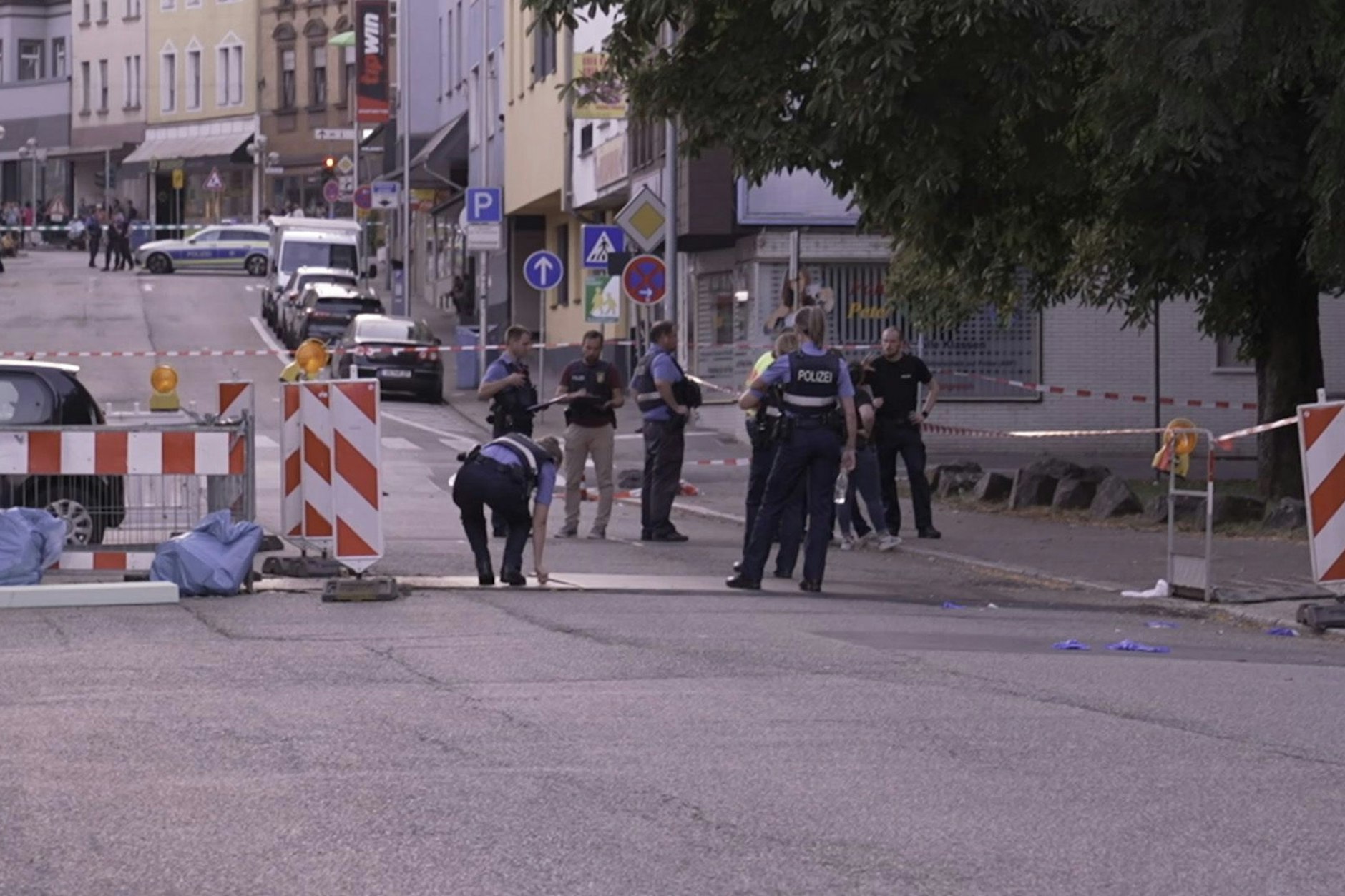 Polizeibeamte untersuchen das Umfeld eines Tatorts.