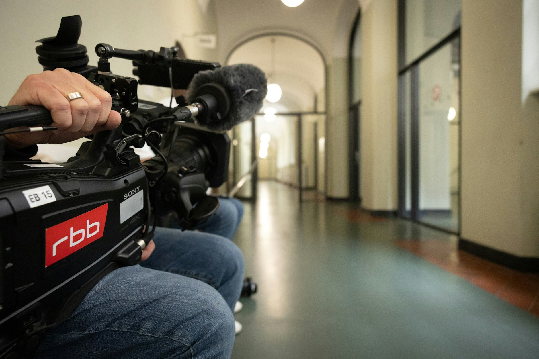 A cameraman waits in front of the courtroom door at the 