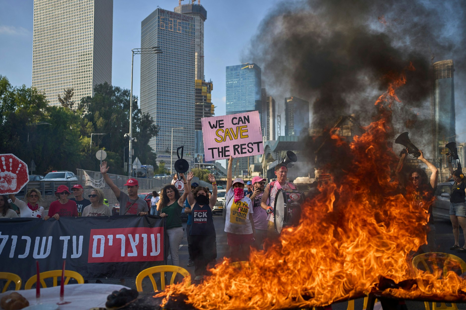 Tel Aviv: Demonstranten blockieren eine Autobahn und verbrennen eine Installation eines Schabbat-Tisches. Sie fordern die sofortige Freilassung der Hamas-Geiseln und fordern die israelische Regierung auf, ihre Entscheidung, die Stadt Gaza und andere Gebiete im Gazastreifen zu übernehmen, rückgängig zu machen.