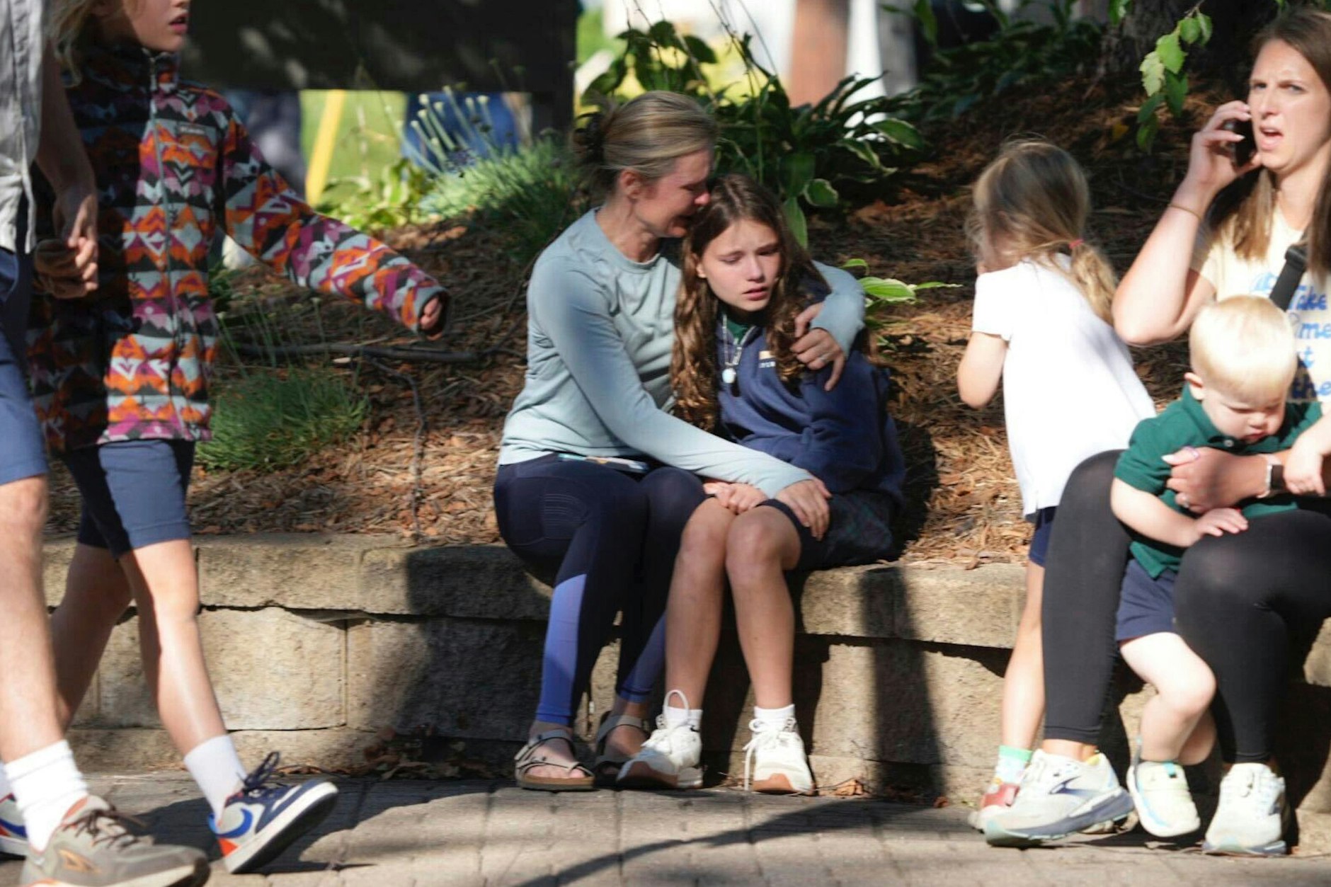 Eltern und Kinder warten in der Nähe der katholischen Schule.